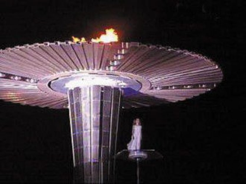 Uma Atleta Abor&iacute;gine acende a pira em Sydney, com formato semelhante a um UFO